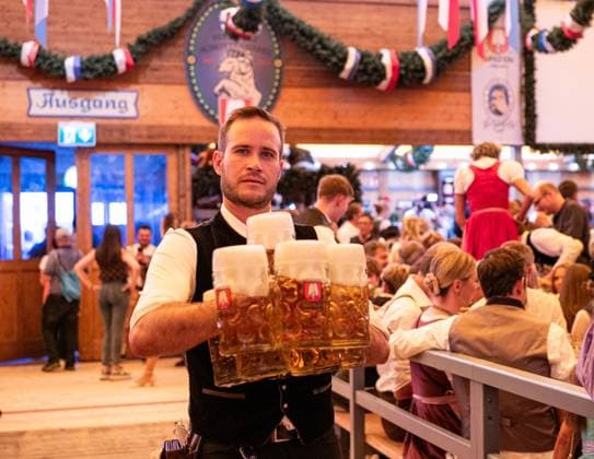 (260919) -- MUNICH, Sept. 19, 2026 -- A staff member carries cups of beer at the Oktoberfest in Munich, Germany, Sept. 19, 2026. The 191st Oktoberfest, one of the largest folk festivals in Germany, opened on Saturday in Munich, with mayor Dominik Krause tapping the first barrel of beer as a tradition. This year s festival will last until Oct. 4. ) GERMANY-MUNICH-OKTOBERFEST-OPENING ZhangxHaofu 