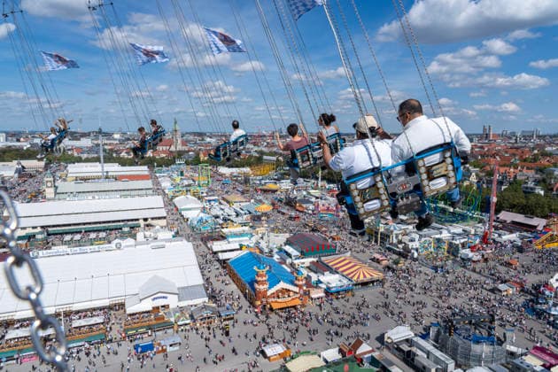 Oktoberfest 2026, Überblick vom BayernTower aus 90 Metern Höhe über die Festzelte hinüber zur Stadt mit dem Wahrzeichen Frauenkirche, Wiesn-Start bei strahlendem Sonnenschein und Temperaturen bis 24 Grad, bestes Wiesnwetter, röffnungstag, 19. Septemb Deutschland, München, 19. September 2026, Oktoberfest 2026, Überblick vom BayernTower aus 90 Metern Höhe über die Festzelte und Fahrgeschäfte hinüber zur Stadt mit dem Wahrzeichen Frauenkirche, Wiesn-Start bei strahlendem Sonnenschein und Temperaturen bis 24 Grad, Samstagmittag um 13:15 Uhr, blauer Himmel, bestes Wiesnwetter, typisch bayerisch, Volksfest, Bayern,