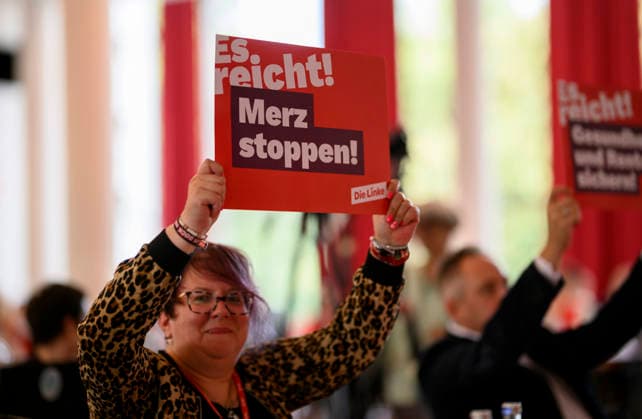 Eine Delegierte hält ein Plakat hoch Merz stoppen es reicht ! , am 19.09.2026 Die Linke NRW Landesparteitag, vom 19.09. - 20.09.2026 in Mülheim an der Ruhr Deutschland. Stadthalle