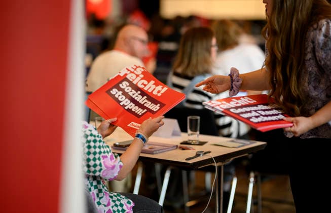 Delegierte teilen Plakate aus Sozialraub stoppen ! es reicht ! , am 19.09.2026 Die Linke NRW Landesparteitag, vom 19.09. - 20.09.2026 in Mülheim an der Ruhr Deutschland. Stadthalle