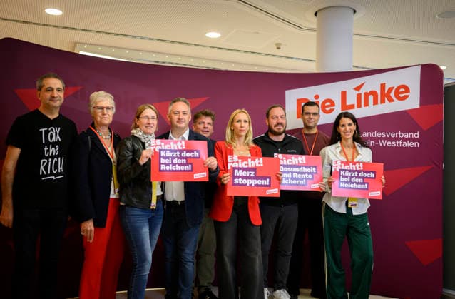 Delegierte halten Plakate Sozialraub stoppen ! Merz stoppen ! kürzt doch bei den Reichen es reicht ! , mit Alexandra Mehdi, Sascha H. Wagner (Sprecher), u.a. am 19.09.2026 Die Linke NRW Landesparteitag, vom 19.09. - 20.09.2026 in Mülheim an der Ruhr Deutschland. Stadthalle
