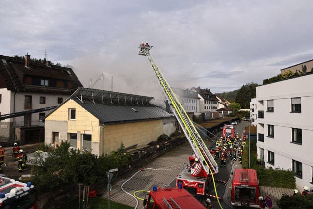 Von der Drehleiter sowie mehrer Feuerwehrleute löschen von der Rückseite des Gebäudes Am Posthaler, Feuer im ehemaliges Werkstattgebäude Naturstein Stefan Wormser, Pestalozzistraße Friedhofsweg Pegnitz, 20.09.2026, Oberfranken, Bayern,