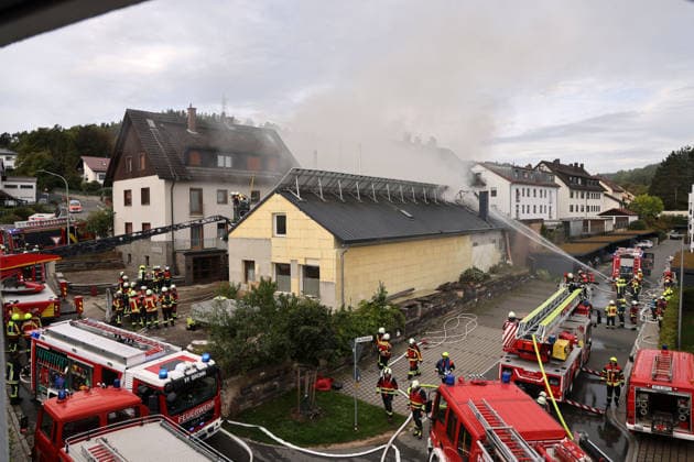 Feuerwehrfahrzeuge sowie Feuerwehrleute im Einsatz im Friedhofsweg und Am Posthaler, Feuer im ehemaligen Werkstattgebäude Naturstein Stefan Wormser, Pestalozzistraße Friedhofsweg in Pegnitz, 20.09.2026, Oberfranken, Bayern,