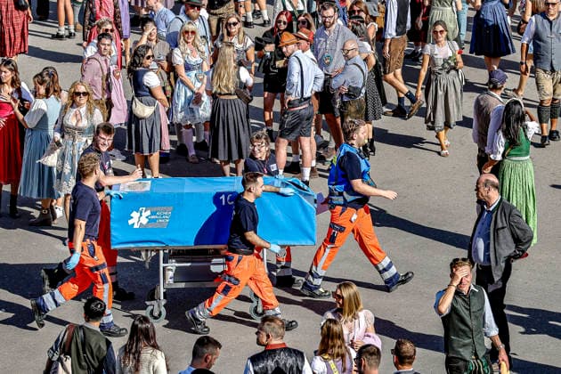 Zehntausende Besucher feiern das Oktoberfest am ersten Wiesn-Tag 2026 in München Impressionen von der Wiesn 2026: Nicht alle Besucher können das Festgelände am Nachmittag auf den eigenen Füßen verlassen. Sanitäter rollen einen Patienten auf einer abgedeckten Trage zu einem Rettungswagen. München Theresienwiese Bayern Germany