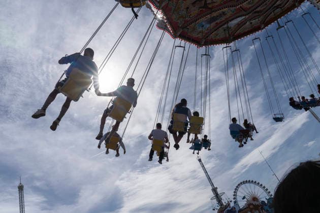 Wiesnbesucher fliegen durch den Münchner Himmel, Kettenkarussell Wellenflug, Oktoberfest, München, 20. September 2026 Deutschland, München, 20. September 2026, Wiesnbesucher fliegen durch den Münchner Himmel im Kettenkarussell Wellenflug, im Gegenlicht der Sonne, Sonntagnachmittag, Oktoberfest, typisch bayerisch, der Himmel ist leicht bewölkt, Wochenende, Volksfest, Bayern,
