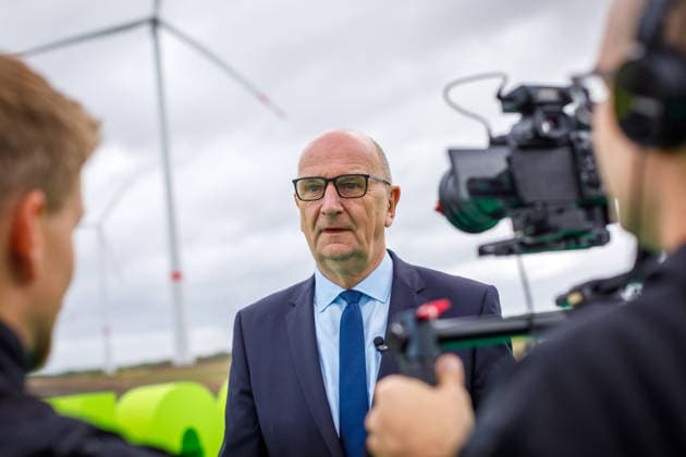 LEAG GigaOne Inbetriebnahme - Dietmar Woidke DEU Deutschland Brandenburg Briesnig, 21.09.2026, Inbetriebnahme GIGA One (LEAG) bei Briesnig im ehemaligen Tagebau Jaenschwalde. Brandenburgs Ministerpraesident Dietmar Woidke (SPD) spricht waehrend der Veranstaltung, im Hintergrund sind Windraeder des neuen Windparks zu sehen. Mit einem Festakt feiert der Energiekonzern LEAG drei Giga-Projekte - die Inbetriebnahme des Windpark Forst-Briesnig 2 und des Energieparks Bohrau 1 sowie dem symbolischen Startschuss fuer die Bauarbeiten zu GigaBattery 1000 in Jaenschwalde.