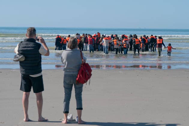 September 21, 2026, Berck, Nord France, France: Berck, France. Holidaymakers watch migrants as they wait in the sea at the beach at Berck-sur-Mer, in northern France, before attempting to cross the English Channel Berck France  - ZUMAl94_ 20260921_zaf_l94_041 Copyright: xIoannisxAlexopoulosx