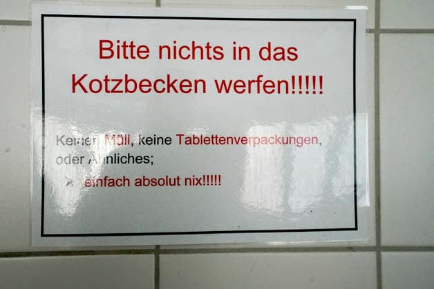 CNTV DROBINN- Innenansicht Hinweisschild Aufschrift Bitte nichts in Kotzbecken werfen an der Wand im Dron Inn Hamburg 21.09.2026 Drob Inn eine Kontakt und Beratungsstelle mit integrierten Drogenkonsumraeumen Hamburg Deutschland