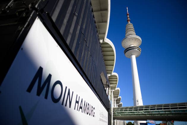 Heinrich-Hertz-Turm auf dem Gelände der Hamburg Messe Hamburg, Deutschland: Blick auf den Heinrich-Hertz-Turm zwischen den Gebäuden und Glasfassaden der Hamburg Messe während der WindEnergy Hamburg. Auf einem Plakat ist der Schriftzug Moin Hamburg zu lesen. Hamburg Hamburg Deutschland