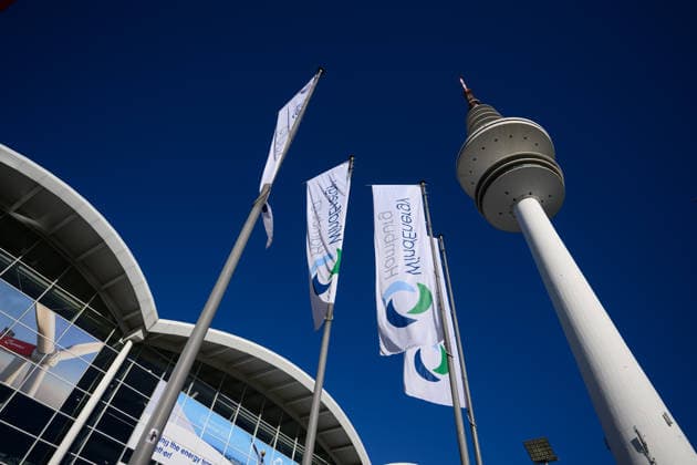WindEnergy Hamburg mit Heinrich-Hertz-Turm Hamburg, Deutschland: Flaggen der WindEnergy Hamburg vor den Messehallen der Hamburg Messe, daneben der Heinrich-Hertz-Turm vor blauem Himmel. Die WindEnergy Hamburg ist eine internationale Fachmesse der Windenergiebranche. Hamburg Hamburg Deutschland