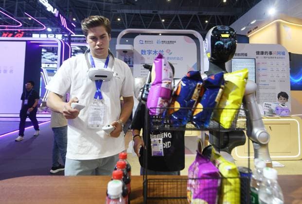 HANGZHOU, CHINA - SEPTEMBER 23: A foreign visitor trains a humanoid robot to sort goods at the Fifth Global Digital Trade Expo on September 23, 2026 in Hangzhou, Zhejiang Province of China. The expo focuses on frontier AI technologies and digital trade innovations.  Copyright: xVCGx 111669003017
