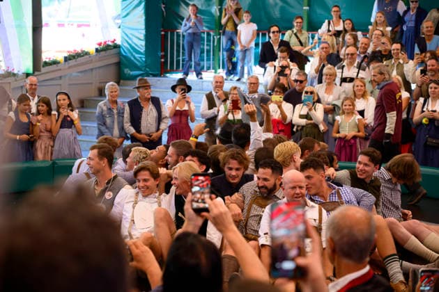 Männer auf dem Teufelsrad im Fahrgeschäft Teufelsrad - Oktoberfest Wiesn, München 23.09.2026