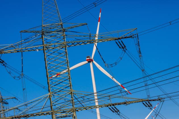 Symbolfoto Windenergie DEU Deutschland Brandenburg Lieskau, 23.09.2026, Symbolfoto Windenergie Energiewende, Windraeder (WEA Windenergieanlagen) sind hinter Stromleitungen und Hochspannungsmasten nahe der Ortschaft Lieskau in Brandenburg zu sehen.