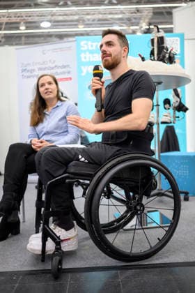 Moritz Brückner r. (Paralympionik, Community-Botschafter) bei der Firma Cyberdyne Care Robotics. REHACARE Fachmesse für Rehabilitation und Pflege, vom 23.09. - 26.09.2026 in Düsseldorf Deutschland. Messe
