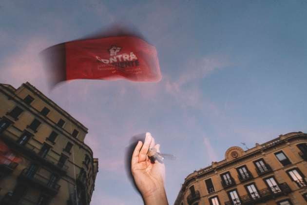 September 23, 2026, Barcelona, Catalonia, Spain: September 23, 2026, Barcelona, Spain: A protester raises a hand as a flag waves overhead at dusk. Hundreds of people gathered in front of the Spanish Government Delegation in Catalonia, on Mallorca Street in Barcelona, at a protest against evictions called by tenants and housing unions, including the Sindicat de Llogateres, the Barcelona Tenants Union. The protest followed the eviction that morning in Madrid of MARICARMEN, an 87-year-old woman forced out of the rented flat where she had lived for seventy years, and the death of OLGA, a woman from L Hospitalet de Llobregat who took her own life after being evicted. The unions warned that they will call a general strike if the Spanish governm - ZUMAs392 20260923_zip_s392_010 Copyright: xFabianxSuspensivox