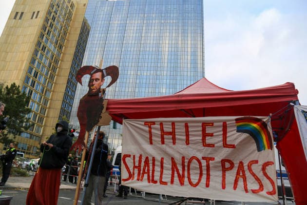 Berlin, Deutschland 24.09.2026: Protest vor dem Axel-Springer-Hochhaus gegen die Verleihung des Axel Springer Awards an Peter Thiel. Zu sehen sind ein Transparent THIEL SHALL NOT PASS mit Regenbogen sowie eine karikierende Figur Thiels mit Hörnern. Demonstration, Protest, Peter Thiel, Palantir, Axel Springer Award, Axel Springer, Transparent, Protestplakat, Karikatur, Regenbogen, LGBTQ, Polizei, Absperrung, Meinungsfreiheit, Kundgebung. Copyright: xAlonxDavidx