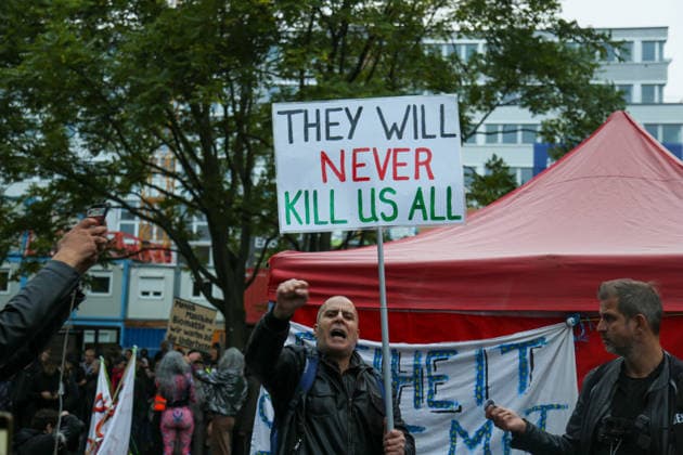 Berlin, Deutschland 24.09.2026: Demonstrant mit erhobener Faust und Protestplakat THEY WILL NEVER KILL US ALL bei der Kundgebung gegen die Verleihung des Axel Springer Awards an Peter Thiel. Demonstration, Protest, Peter Thiel, Palantir, Axel Springer Award, Axel Springer, Demonstrant, Protestplakat, Transparent, erhobene Faust, Palästina, Nahost, Aktivismus, Kundgebung, Protestbewegung. Copyright: xAlonxDavidx