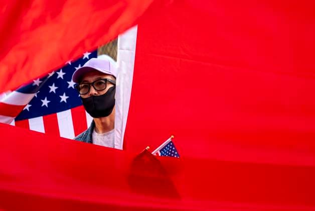 Xi Visit - Washington, USA - 24 Sep 26 A pro-China demonstrator peers through flags during a protest and counterprotest over China s role in Tibet. U.S. President Donald Trump is hosting China s President Xi Jinping for a state visit. Washington United States Copyright: xJenxGolbeckx xSOPAxImagesx Jen-Golbeck-1453640