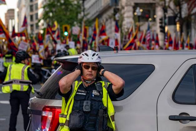 Xi Visit - Washington, USA - 24 Sep 26 A police officer covers his ears during a protest and counterprotest over China s policy in Tibet. U.S. President Donald Trump is hosting China s President Xi Jinping for a state visit. Washington United States Copyright: xJenxGolbeckx xSOPAxImagesx Jen-Golbeck-1453641