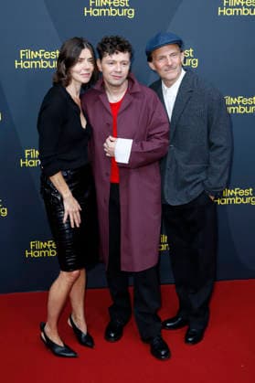 Malgorzata Szumowska, Christian Friedel und Michal Englert bei der Festivaleröffnung mit der Premiere des Kinofilms The Idiot(s) auf dem 34. Filmfest Hamburg 2026 im Cinemaxx Dammtor. Hamburg, 24.09.2026