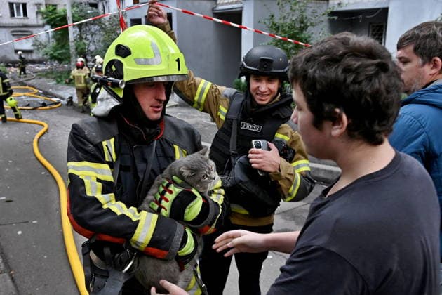 Aftermath of a Russian drone attack in Kyiv, Ukraine - 25 Sept 2026 A firefighter hands a rescued cat to its owner at the site where a Russian strike drone hit an apartment building during a Russian attack on the country. Kyiv Ukraine Copyright: xAleksandrxGusevx xSOPAxImagesx Oleksandr_Gusev_Pechersk_25092026