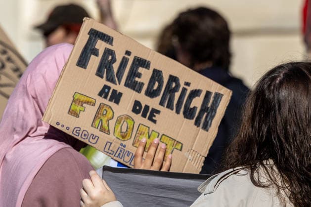 Schulstreik gegen Wehrpflicht in Frankfurt 25.09.2026: Mädchen hält Plakat hoch mit der Aufschrift: Friedrich an die Front , gemeint ist vermutlich Kanzler Friedrich Merz. Schüler und junge Menschen demonstrieren bei einem Schulstreik gegen die Wehrpflicht in Frankfurt am Main. Die Demonstration startete an der Alten Oper und richtet sich gegen eine Wiedereinführung beziehungsweise Ausweitung der Wehrpflicht und verpflichtender Musterungen. Die Teilnehmer fordern unter anderem mehr Mitsprache junger Menschen in der Wehrpflichtdebatte und setzen sich nach Angaben der Veranstalter gegen Militarisierung und für Investitionen in Bildung ein. Der Protest ist Teil bundesweiter Schulstreiks gegen die Wehrpflicht. Frankfurt am Main Alte Oper