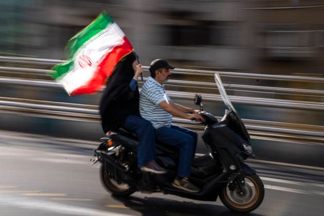 September 25, 2026, Tehran, Iran: A woman holds the Iranian flag as they ride a motorcycle during the 40,000-strong Sacrifice for Iran motorcycle rally. Tehran Iran  - ZUMAs197 20260925_aaa_s197_009 Copyright: xFoadxAshtarix
