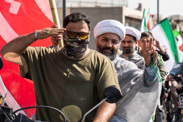 September 25, 2026, Tehran, Iran: A cleric shows a victory sign while a man in front of him gives a military salute during the 40,000-strong Sacrifice for Iran motorcycle rally. Tehran Iran  - ZUMAs197 20260925_aaa_s197_010 Copyright: xFoadxAshtarix