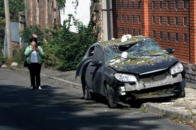 A woman holding a phone stands by a car damaged by a Russian drone strike, Kyiv, Ukraine, September 25, 2026. The attack injured at least six people and damaged the High Council of Justice building. (Photo by Kyrylo Chubotin Ukrinform) Aftermath of Russian attack on Kyiv on September 25, 2026  Copyright: xKirillxChubotinx