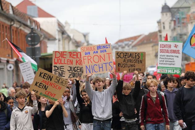 Demonstranten laufen mit Schildern Kein Mensch Kein Cent der Bundeswehr, Die Reichen wollen Krieg Die Jugend eine Zukunft, Schule bringt Dir an der Front nichts und Soziales aufrüsten Rüstung kürzen in der Friedrich-Ebert-Straße während einer Demonstration gegen die Wehrpflicht, Potsdam, 25. September 2026. Schulstreik gegen Wehrpflicht in Potsdam