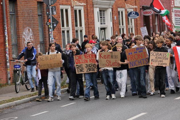 Demonstranten laufen mit Schildern Nein zum Musterungszentrum, Die Reichen wollen Krieg Die Jugend eine Zukunft, Kein Werben fürs Sterben, Schule bringt Dir an der Front nichts und Soziales aufrüsten Rüstung kürzen in der Kurfürstenstraße während einer Demonstration gegen die Wehrpflicht, Potsdam, 25. September 2026. Schulstreik gegen Wehrpflicht in Potsdam