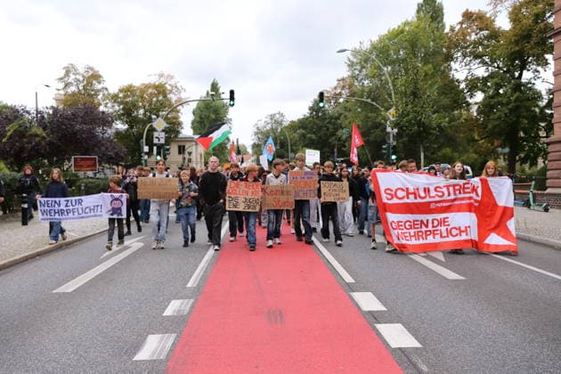 Demonstranten laufen mit Banner Nein zur Wehrpflicht, mit Schildern Nein zum Musterungszentrum, Die Reichen wollen Krieg Die Jugend eine Zukunft, Kein Werben fürs Sterben, Schule bringt Dir an der Front nichts und Soziales aufrüsten Rüstung kürzen sowie Banner Schulstreik gegen die Wehrpflicht in der Behlertstraße während einer Demonstration gegen die Wehrpflicht, Potsdam, 25. September 2026. Schulstreik gegen Wehrpflicht in Potsdam