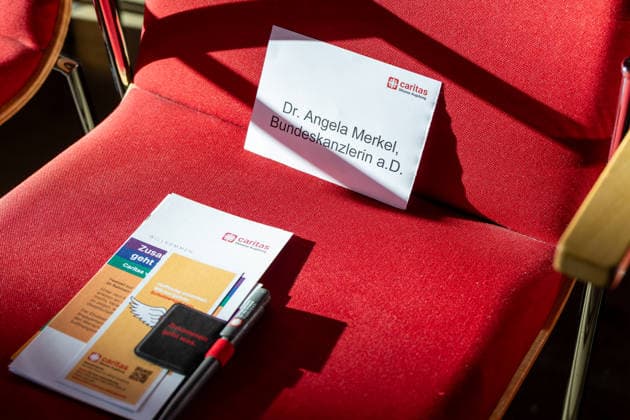 Bundeskanzlerin a. D. Angela Merkel (CDU) bei der Verleihung des Elisabethpreises der Caritas im Goldenen Saal des Augsburger Rathauses. Namensschild auf dem Stuhl von Dr. Angela Merkel, Bundeskanzlerin a.D.