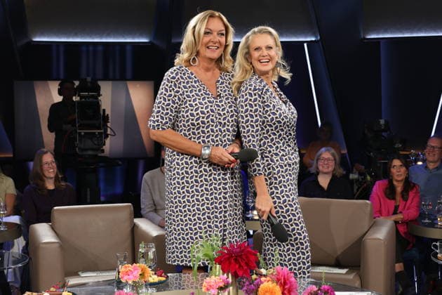 Es kommt selten vor, daß sie gemeinsam moderieren, und nun das: Bettina Tietjen und Barbara Schöneberger tragen durch Zufall fast das gleiche Outfit, Tietjen trägt ein Kleid und Schöneberger kam im Jumpsuit, beides gekauft im Modehaus Stegmann am feinen Hamburger Jungfernstieg, NDR Talk Show, Fototermin am 25.9.2026 im Fernsehstudio Hamburg-Lokstedt vor der Sendung im 3. Programm des NDR Fernsehen