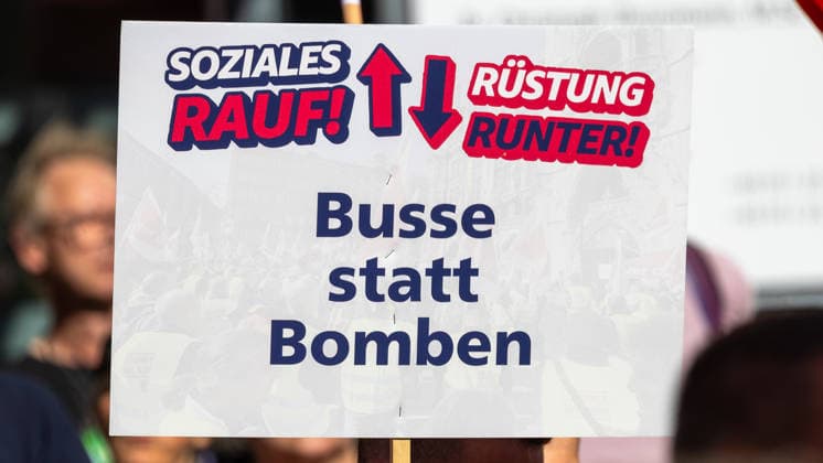 DGB Bayern - Hart verdient! Groß-Kundgebung, Nürnberg, 26.09.2026 Ein Demonstrant hält ein Plakat mit der Aufschrift Soziales rauf! Rüstung runter! Busse statt Bomben in die Höhe. Das Schild fordert höhere Sozialausgaben und eine Reduzierung der Rüstungsausgaben. Nürnberg Bayern Deutschland