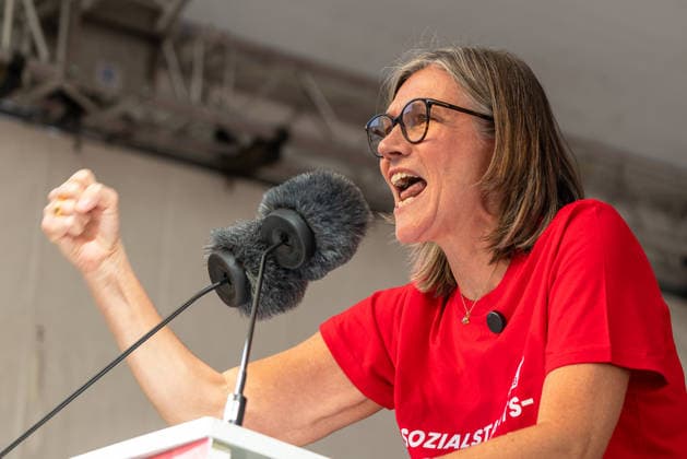 DGB Bayern - Hart verdient! Groß-Kundgebung, Nürnberg, 26.09.2026 Christiane Benner, Erste Vorsitzende der IG Metall, spricht bei einer Kundgebung mit erhobener Faust und leidenschaftlicher Mimik ins Mikrofon. Die Rednerin trägt ein rotes T-Shirt mit der Aufschrift Sozialstaats- und wirkt entschlossen und energisch. Nürnberg Bayern Deutschland