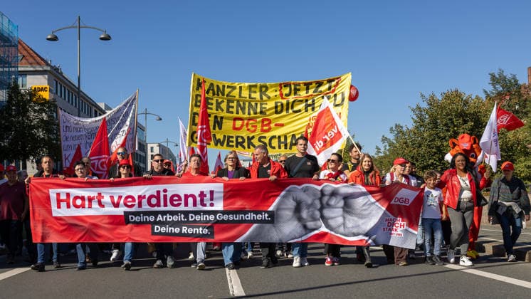 DGB Bayern - Hart verdient! Groß-Kundgebung, Nürnberg, 26.09.2026 Demozug am Frauentorgraben zur Kundgebung Hart verdient! des DGB, angeführt von einem großen roten Transparent mit Faust-Symbol. In der Mitte der ersten Reihe läuft Christiane Benner, Erste Vorsitzende der IG Metall, konzentriert und entschlossen zwischen weiteren Teilnehmenden. Nürnberg Bayern Deutschland