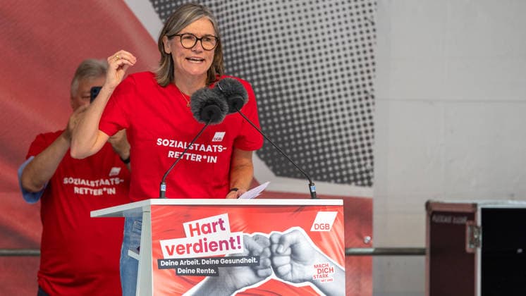 DGB Bayern - Hart verdient! Groß-Kundgebung, Nürnberg, 26.09.2026 Christiane Benner, Erste Vorsitzende der IG Metall, spricht mit energischer Geste am Rednerpult bei einer Kundgebung des DGB. Im Hintergrund applaudiert ein Teilnehmer in rotem T-Shirt mit der Aufschrift Sozialstaats-Retter*in . Nürnberg Bayern Deutschland