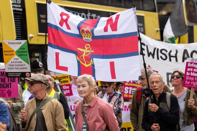 September 26, 2026, Manchester, United Kingdom: Protesters hold a banner with RNLI (Royal National Lifeboat Institution) during the rally. Activists in Manchester march for Stand Up To Racism against the far right. In addition to anti-racist slogans promoting diversity and migrant rights, demonstrators carried banners of the RNLI (Royal National Lifeboat Institution) following recent Patriot Platform protests. The broad coalition of trade unions, community groups, and political organisations featured prominent banners from BECTU (Broadcasting, Entertainment, Communications and Theatre Union) and Jewish Voice for Labour (JVL). Manchester, United Kingdom. Manchester United Kingdom  - ZUMAs197 20260926_aaa_s197_218 Copyright: xGaryxRobertsx