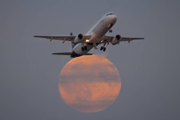 Vollmond Ein Flugzeug fliegt kurz nach dem Abflug vom Frankfurter Flughafen vor dem gerade aufgehenden Vollmond vorbei. Frankfurt am Main Flughafen Hessen Deutschland