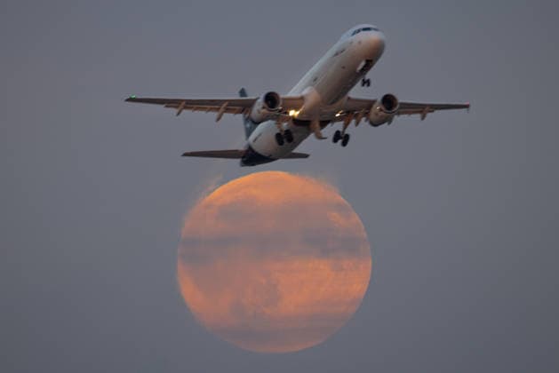 Vollmond Ein Flugzeug fliegt kurz nach dem Abflug vom Frankfurter Flughafen vor dem gerade aufgehenden Vollmond vorbei. Frankfurt am Main Flughafen Hessen Deutschland