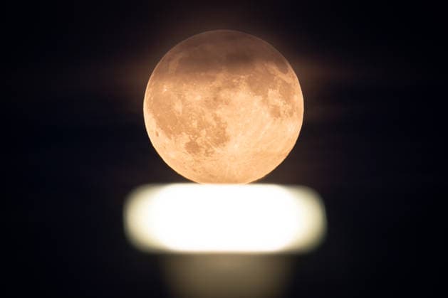 Vollmond Der Vollmond leuchtet über einem Scheinwerfer auf dem Rollfeld des Frankfurter Flughafens. Frankfurt am Main Flughafen Hessen Deutschland
