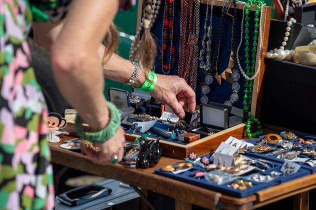 September 26, 2026, London, United Kingdom: A stallholder at the King™s Cross Classic Car Boot Sale sorts through a tray of jewellery. The Kings Cross Classic Car Boot Sale returned to Granary Square and Stable Street, King™s Cross, London, for its 11th year. Held several times throughout the year, the event brings together vintage fashion, second-hand clothing, jewellery, homewares, collectables and vinyl records alongside classic cars, motorcycles and commercial vehicles. Visitors browsed stalls and traders, with many making a special effort to dress in period clothing inspired by the 1950s, 1960s and 1970s.continuing a tradition associated with the event. London United Kingdom - ZUMAs197 20260926_aaa_s197_360 Copyright: xJamesxWilloughbyx