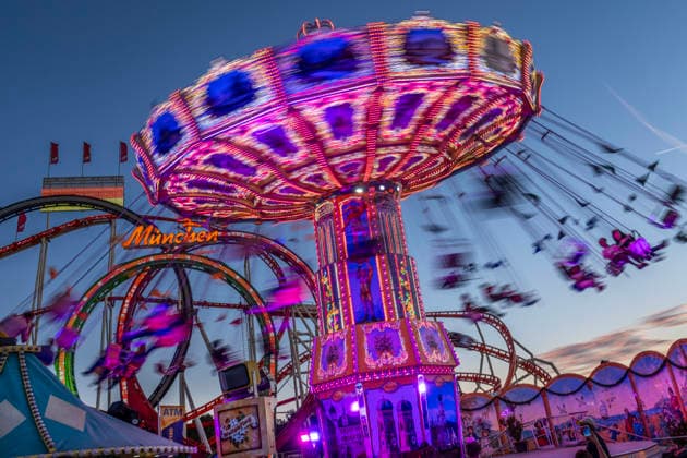 Oktoberfest 2026, Flug durch den Abendhimmel, Kettenkarussel Wellenflug vor dem Olympia Looping, bestes Wiesnwetter, Sonntag, 27. September 2026 Deutschland, München, 27. September 2026, Oktoberfest 2026, Flug durch den Abendhimmel, Kettenkarussel Wellenflug vor dem Olympia Looping, Langzeitbelichtung, bestes Wiesnwetter, typisch bayerisch, Volksfest, Sonntagabend um 19 Uhr, Blaue Stunde, Wochenende, Bayern,