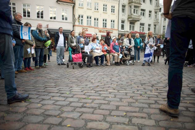 Flensburg, Schleswig-Holstein Flensburg gedenkt den Opfern des 7. Oktober 2023. Teilnehmer versammeln sich auf dem Südermarkt. Es werden Lieder gesungen und die Namen und Geschichten einzelner Opfer des Terroranschlages vorgelesen. Aufnahme vom 07.10.2026, Flensburg