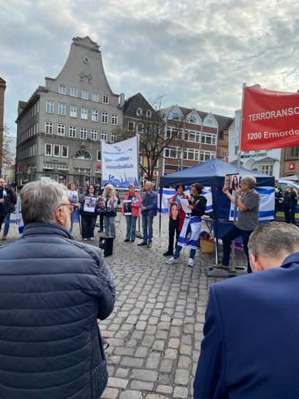 Flensburg, Schleswig-Holstein Flensburg gedenkt den Opfern des 7. Oktober 2023. Teilnehmer versammeln sich auf dem Südermarkt. Es werden Lieder gesungen und die Namen und Geschichten einzelner Opfer des Terroranschlages vorgelesen. Aufnahme vom 07.10.2026, Flensburg