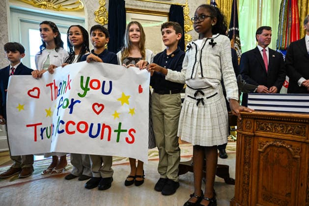 Trump Makes Oval Office Announcement WASHINGTON, DC - OCT. 7: Kids hold up a sign as US President Donald Trump speaks during an announcement on Trump Accounts in the Oval Office on Wednesday, Oct. 7, 2026 at the White House in Washington, D.C. (Photo by Annabelle Gordon Pool For The Washington Post) Washington DC United States  Copyright: xPool ABACAx