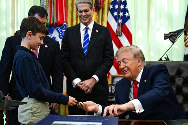 Trump Makes Oval Office Announcement WASHINGTON, DC - OCT. 7: US President Donald Trump hands a challenge coin and a pen to a child during an announcement on Trump Accounts in the Oval Office on Wednesday, Oct. 7, 2026 at the White House in Washington, D.C. (Photo by Annabelle Gordon Pool For The Washington Post) Washington DC United States  Copyright: xPool ABACAx