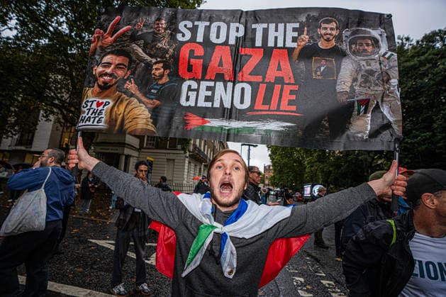 Pro-Israeil counter protestors challenge pro-Palestine demonstrators in London, UK - 7 OCT 2026. A protester seen holding a banner bearing words in white and red colour STOP THE GAZA GENO LIE Pro-Palestine activists from Central London Universities chose the 3rd anniversary of the October 7th attack by Hamas to protest against Israel’s war on Gaza. They clashed en route with pro-Israeli counter protestors. The demonstration was arranged by an inter-uni coalition that includes King’s College and LSE. London United Kingdom Copyright: xLabxMox xSOPAxImagesx LabMO_Oct_7th_Uni_Protest_SOPA_30