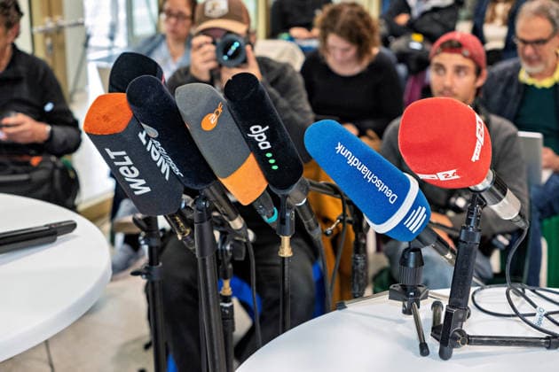Berlin, 08.10.2026: Mikrofone von Welt, ZDF, dpa, Deutschlandfunk und rbb24 stehen vor dem gemeinsamen Pressestatement von Die Linke Berlin, Bündnis 90 Die Grünen Berlin und SPD Berlin zum Abschluss der Vorgespräche im Foyer des Hauses der Statistik bereit, dahinter warten Journalisten. Pressestatement von Linke, Grünen und SPD in Berlin